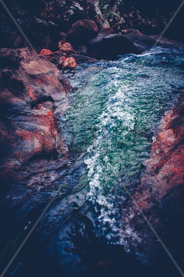 Cascada entre rocas con paisaje