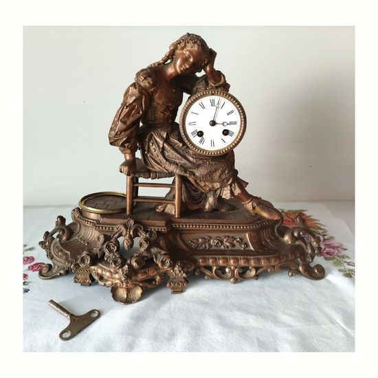 clock with a striking sculpture of a girl sitting Metal Mixta