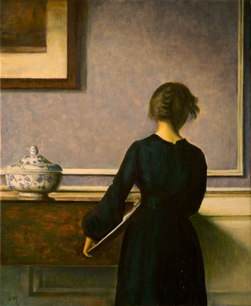 Interior con mujer joven vista de espaldas