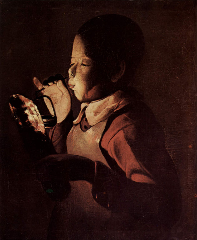 The boy blows on a lamp