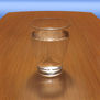UN VASO DE AGUA SOBRE UNA MESA DE MADERA