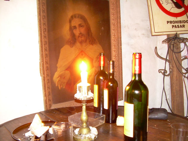 Dios con vela y vino tinto.