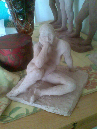 Figura humana sentada y pensativa. 