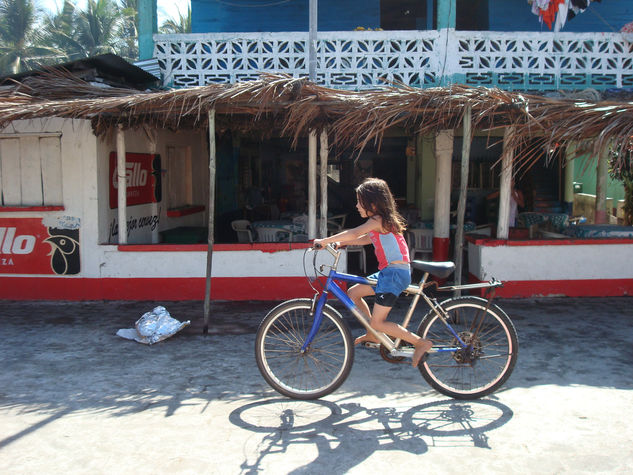 Niña por la playa en su bicicleta 