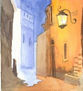 Calle con charco y farol encendido
