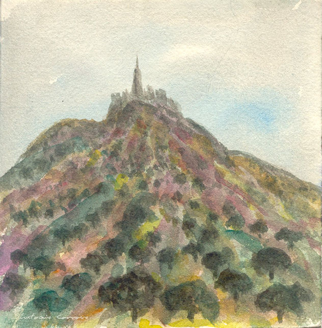 Pueblo encima de un monte y encinas