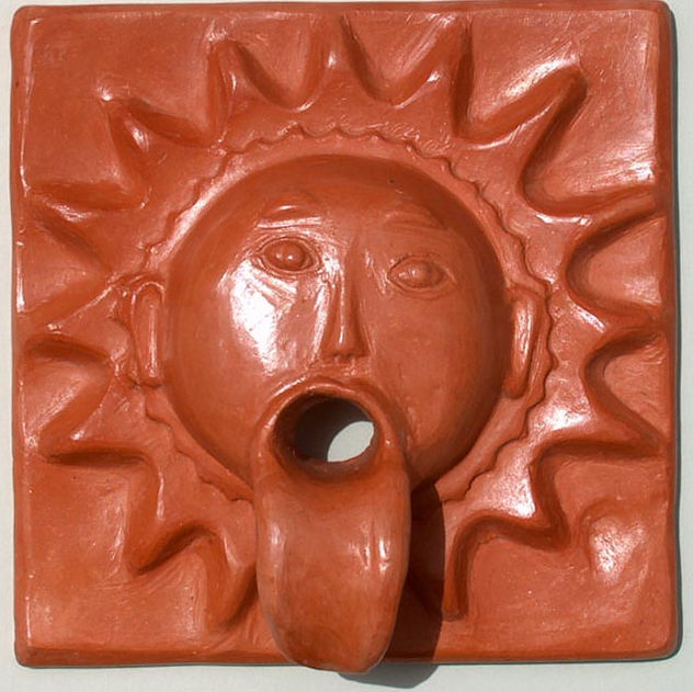 Gargola pequeña sol cara con lengua