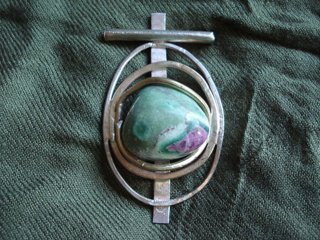 Amuleto de circulos con piedra rosa