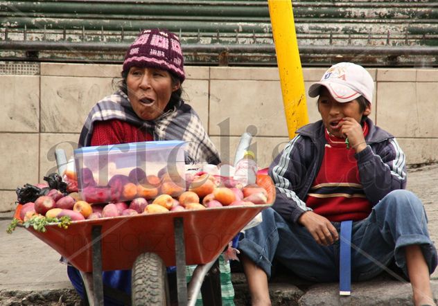 Madre e hijo vendiendo fruta.