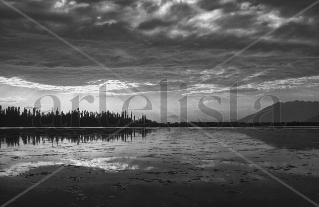 The sun is breaking through the clouds over the Dal - Lake